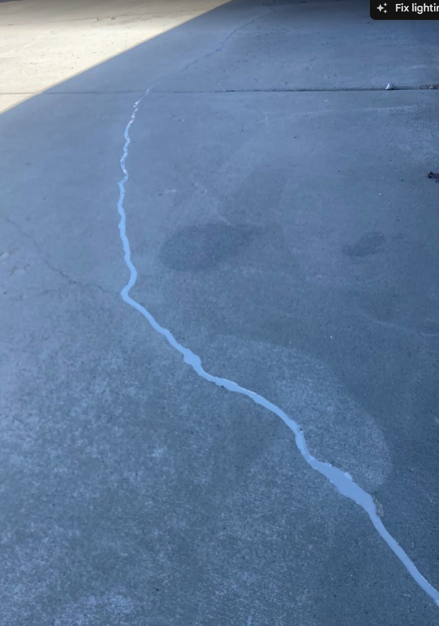 Concrete driveway crack sealed with polyurethane sealant after repair