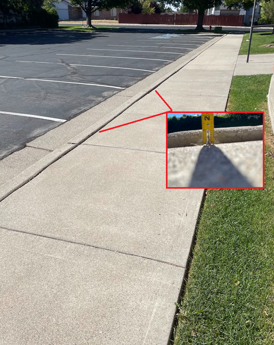 Settled sidewalk at curb in Park City creating a tripping hazard before concrete lifting