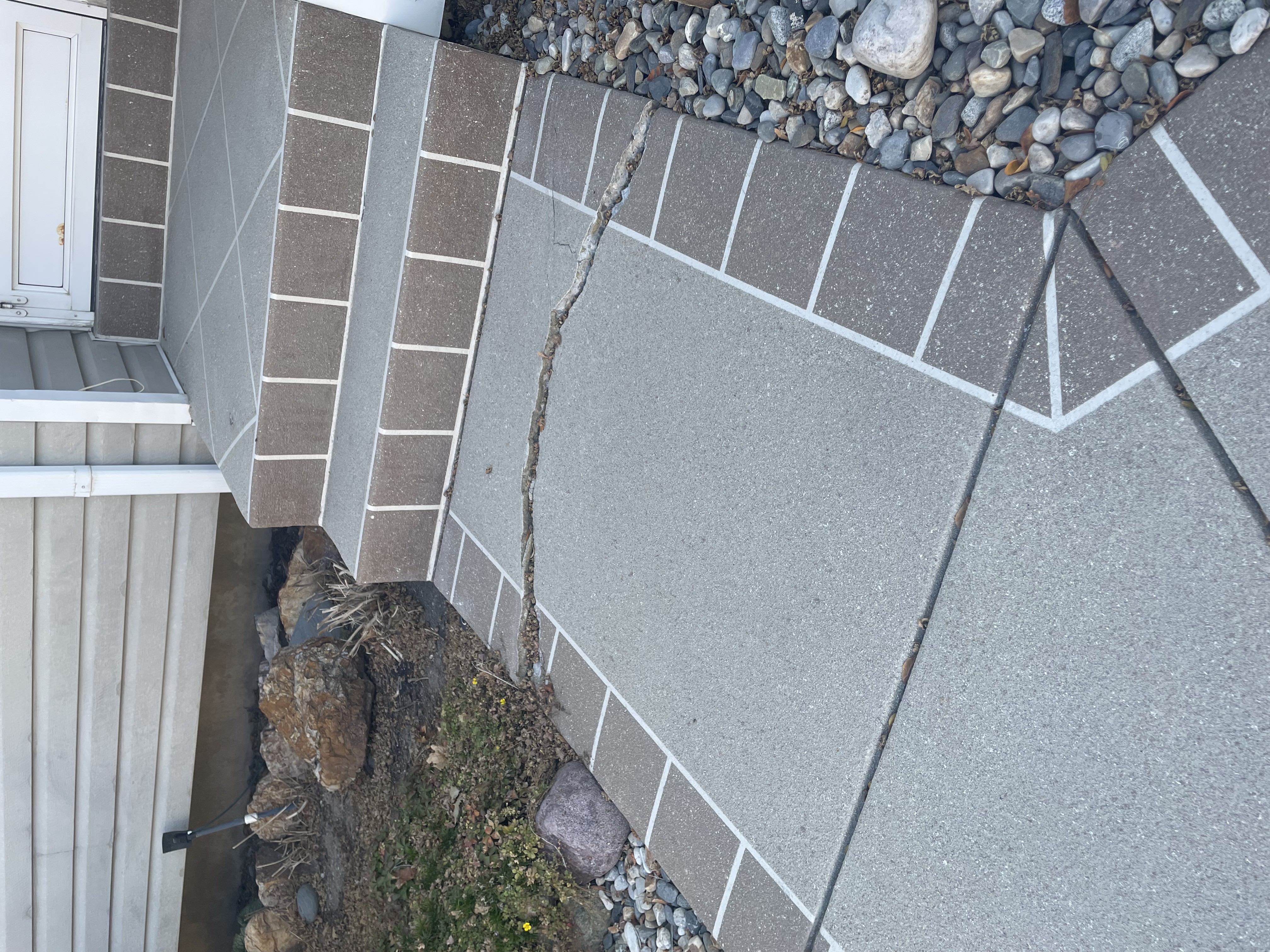 Sunken cracked sidewalk before concrete lifting